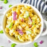 Bowl of gluten free macaroni salad with blue and white strip towel